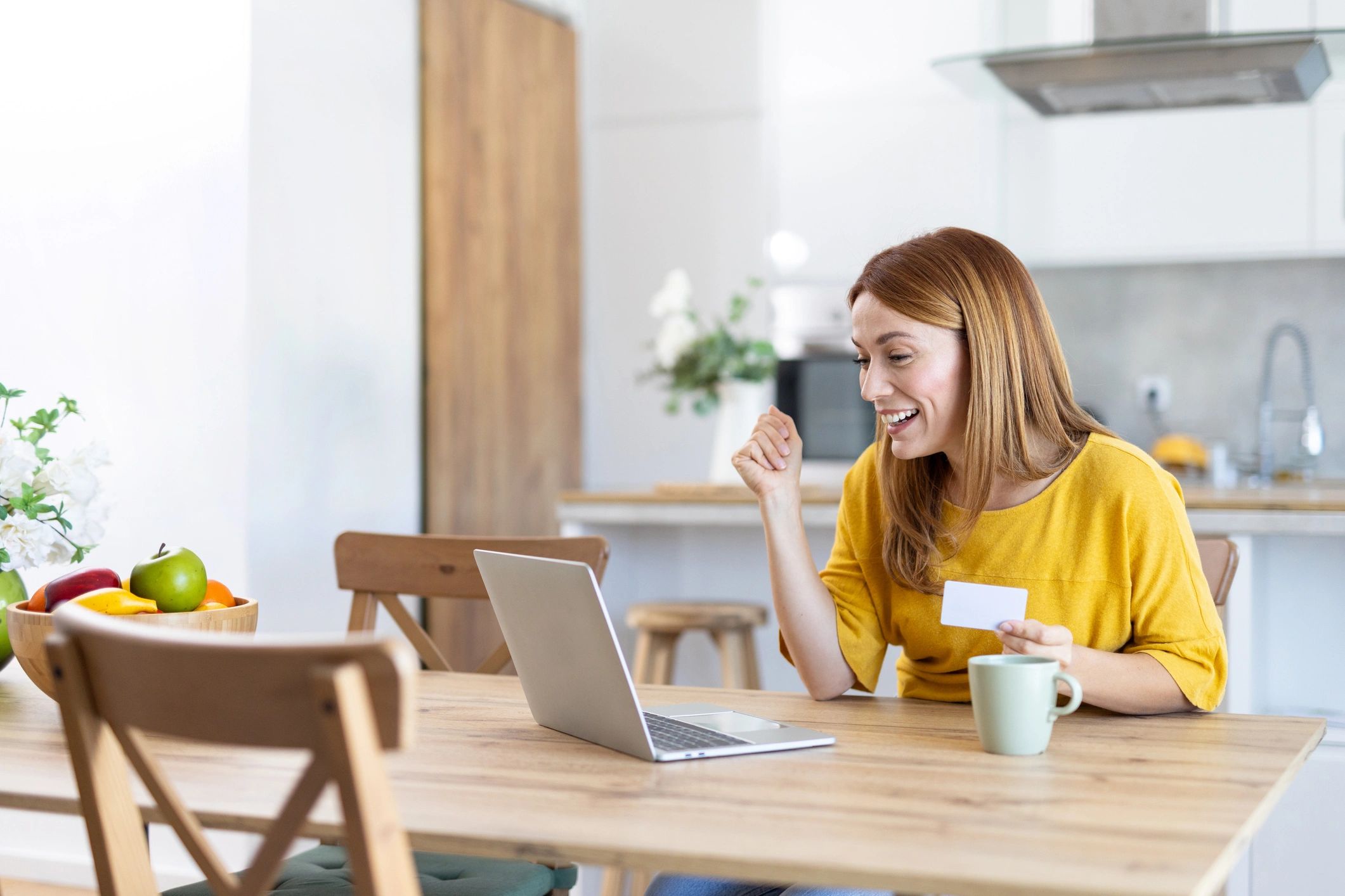 Person shopping online on a laptop, celebrating a great deal